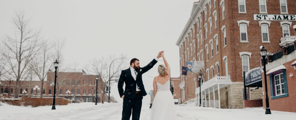 couple twirling in wedding dress and tux in winter