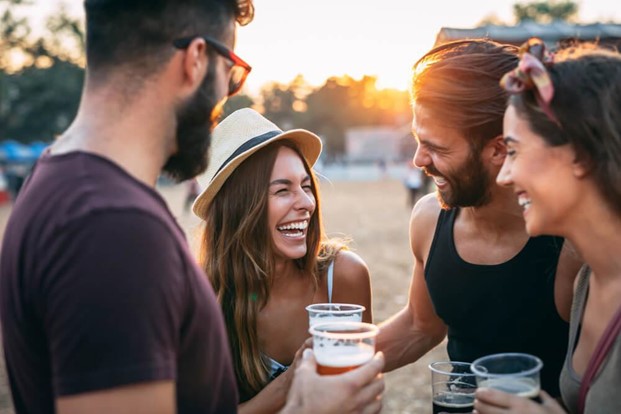 Group of friends laughing and holding adult beverages